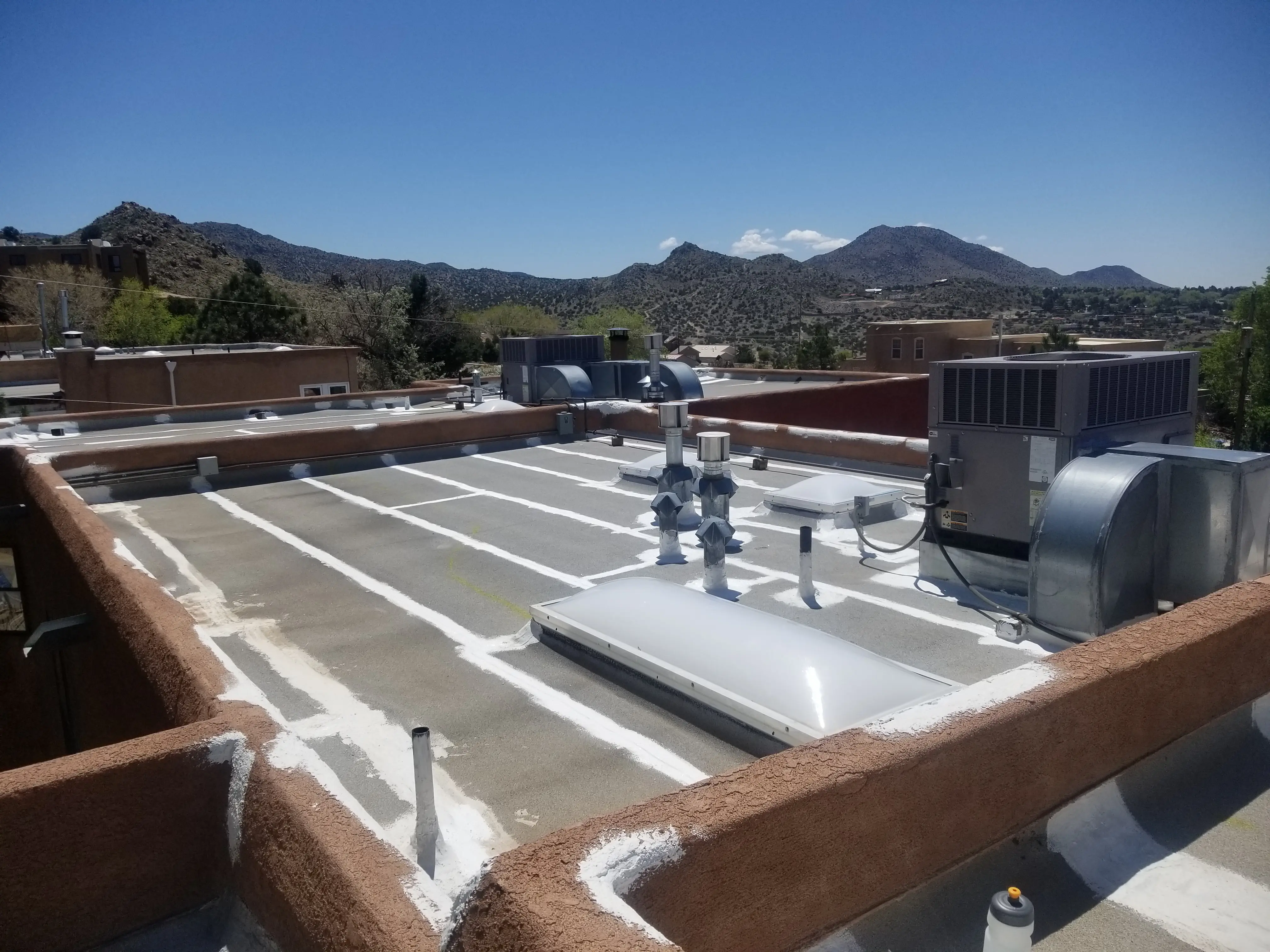 Roof prepared with Armor roof mastic on all seams and flashings — white mastic visible on gray roof material